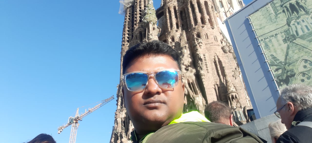 car interior from central back seat position showing driver and blurred view through windscreen of a busy road at night