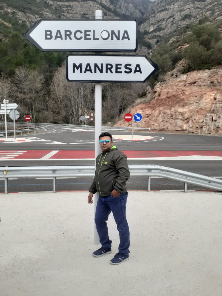 car interior from central back seat position showing driver and blurred view through windscreen of a busy road at night
